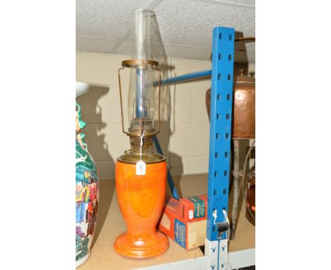 A CROWN DEVON ORANGE LUSTRE OIL LAMP, the reservoir being brass, with single burner and glass chimney in place, height 65.5cm