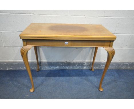 A REPRODUCTION WALNUT CARD TABLE, with a fold over top enclosing a playing surface, along with a playing cards  and other car