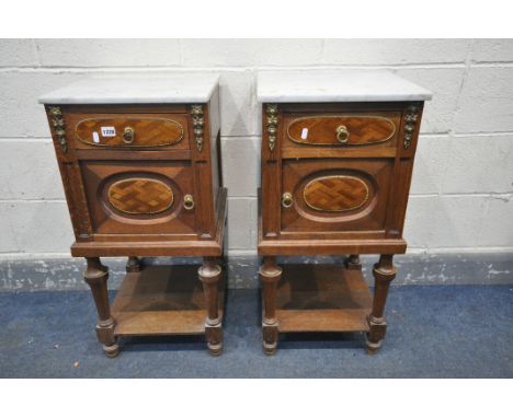 AN OPPOSING PAIR OF EARLY 20TH CENTURY OAK FRENCH POT CUPBOARD/BEDSIDE CABINETS, with marble top, brass mounts, with single d