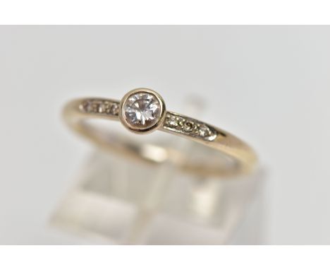 AN 18CT GOLD DIAMOND DRESS RING, the brilliant cut diamond within a collet setting, to the similarly cut diamond line shoulde