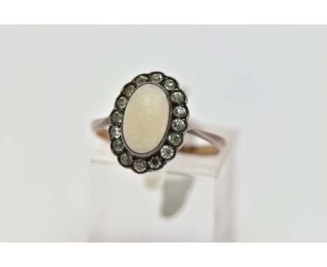 A MID 20TH CENTURY OPAL AND PASTE CLUSTER RING, set with a principal oval opal cabochon, within a colourless paste surround, 