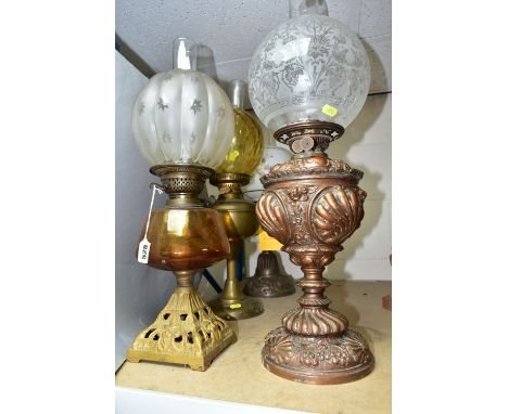 FOUR EARLY 20TH CENTURY OIL LAMPS, comprising a metal based lamp with  hand painted  flowers on a ceramic reservoir, a white 