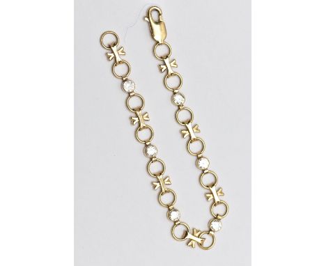 A YELLOW METAL CUBIC ZIRCONIA LINE BRACELET, designed with six collet set, circular cut colourless cubic zirconia, interspace