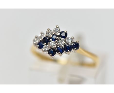 AN 18CT YELLOW AND WHITE GOLD SAPPHIRE AND DIAMOND DRESS RING, the marquise shape tiered cluster set with two lines of round 