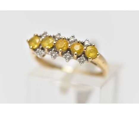 A 9CT GOLD GEM SET RING, designed with a central row of five circular cut yellow stones assessed as topaz, between two rows o