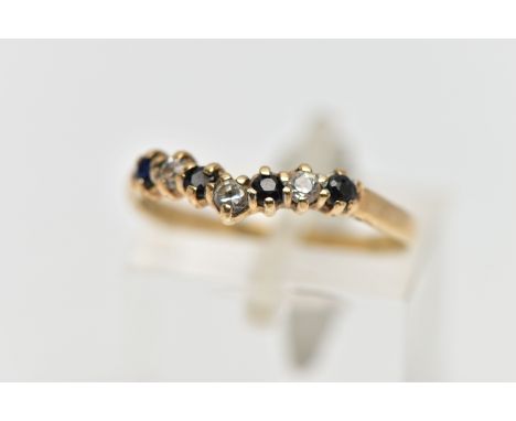 A 9CT GOLD GEM SET WISH BONE RING, designed with a row of four claw set, circular cut sapphires interspaced with three colour