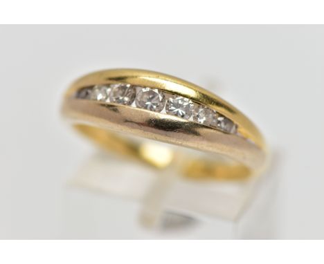 AN 18CT GOLD SEVEN STONE DIAMOND RING, designed as a graduated series of brilliant cut diamonds within a tension half eternit