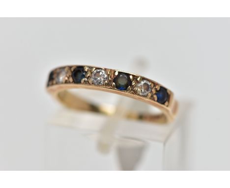 A 9CT GOLD SAPPHIRE AND DIAMOND HALF ETERNITY RING, designed with a row of four claw set, circular cut deep blue sapphires, i