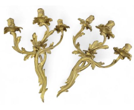 A pair of Rococo style gilt brass three branch wall light fittings 41cms high
