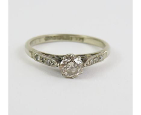 An old cut diamond solitaire ring, with diamond set shoulders, marked '18ct plat' (all white metal), finger size N, 2.5g gros