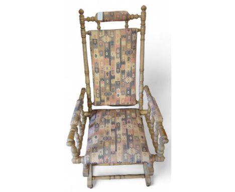 A 20th century American rocking chair, in a light wood, and with upholstered seat, back, arms and head rest