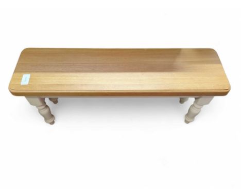 A modern light oak top bench, on white base, with four turned legs, 1.06m long, 47cm high, 30.5cm deep
