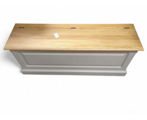 A modern painted ottoman, with light oak hinged lid, and panel front, 1.25m long, 49cm high, 36cm deep