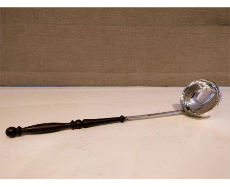 An C18th Georgian white metal toddy ladle, having an oval bowl with turned and decorated fruitwood handle. L: 33 cm