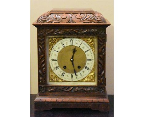 An early C20th oak cased bracket clock, the case heavily carved with enamel and brass dial, H 33cm x W 22cm 