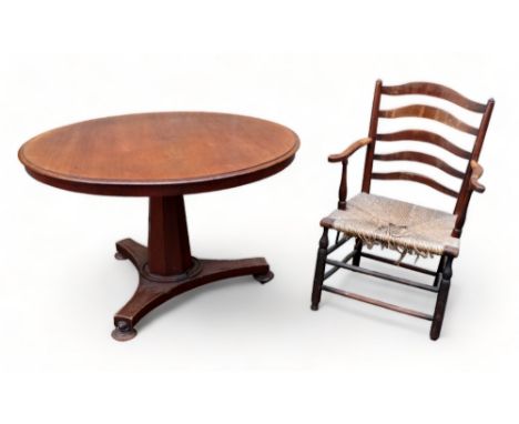 A Victorian mahogany loo table - the circular top above an octagonal tapering support and triform base with flat bun feet and