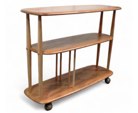 An Ercol elm and beech Baby Giraffe three tier trolley - model 361, incorporating a magazine divider and raised on castors, 9