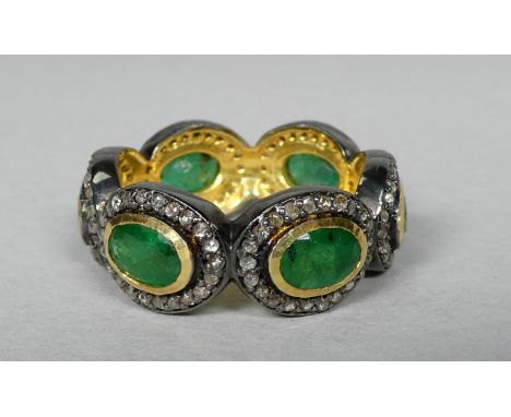 A full eternity ring set with oval emeralds - each emerald surrounded by a halo of diamonds, the emeralds weighing 2.55ct app