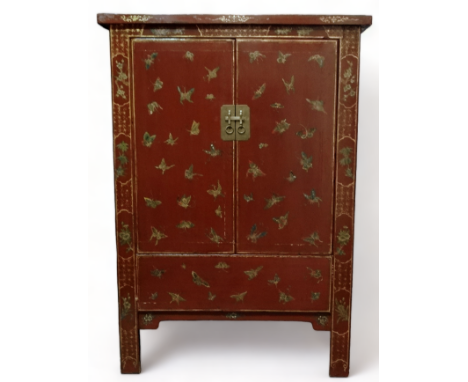 A 19th century Chinese lacquered cabinet - decorated with butterflies and cherry blossom, the pair of panel doors enclosing a