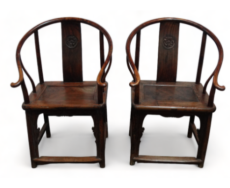 A pair of late 19th century Chinese oriental hardwood horseshoe back chairs - with carved contoured splats above a panel seat