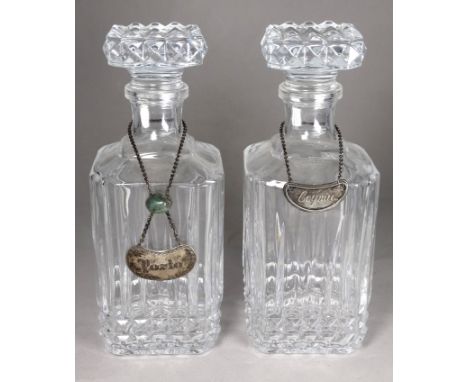 A pair of pressed glass decanters - with square stoppers and bodies and silver plated decanter labels, height 26cm. 