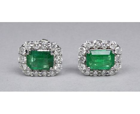 A pair of 18ct white gold cluster earrings set emeralds and diamonds - the central step cut emeralds weighing 1.46ct approxim