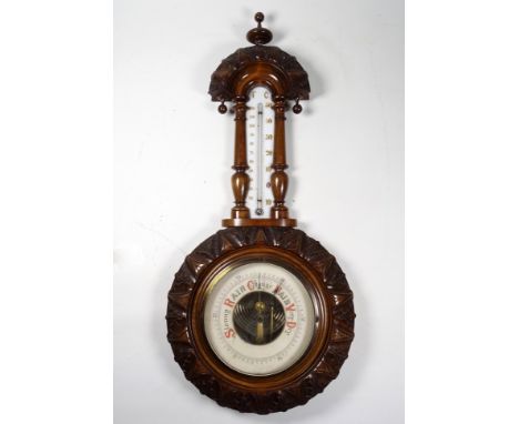A late 19th century stained beech aneroid barometer - leaf carved incorporating a thermometer, height 51cm.