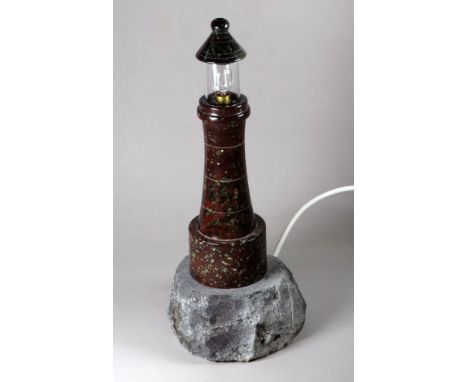 A Cornish turned serpentine table lamp in the form of a lighthouse - mounted on a rocky base, height 39cm.