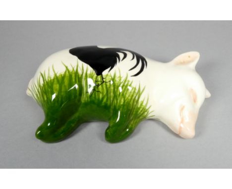 A Wemyss Griselda Hill pottery pig - recumbent, decorated with a black hen, width 17cm.