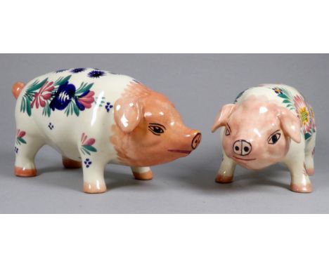 A Quimper pottery piggy bank - decorated with flowers, width 21cm, together with another Quimper pottery pig. (2)