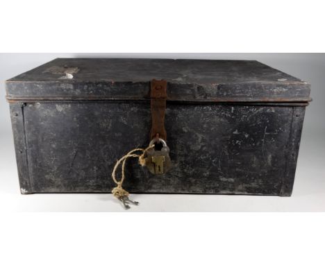 A black painted tin trunk - rectangular with bail handles, the lid with a luggage label, fitted with a brass old English styl
