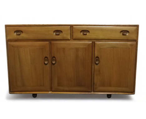 An Ercol elm sideboard - of Windsor pattern with a pair of drawers above panel doors, one enclosing a cutlery drawer, and rai