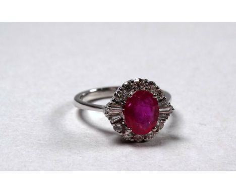 An 18ct white gold ruby and diamond set cluster ring - the central oval ruby weighing 1.59ct approximately, the diamonds weig