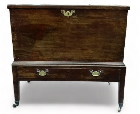 A 19th century mahogany trunk - with rectangular top and brass bale handles on a low stand with square tapering legs ending i