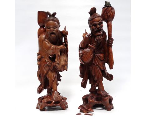 A pair of 20th century Chinese carved hardwood lamp bases - modelled as tradesmen, height 53cm.
