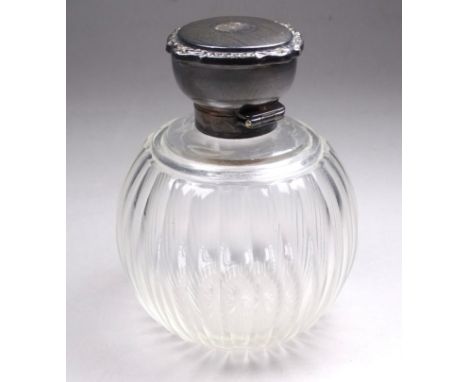 A silver mounted fluted glass scent bottle - Birmingham 1922, globe shaped with an engine turned cover, height 11cm.