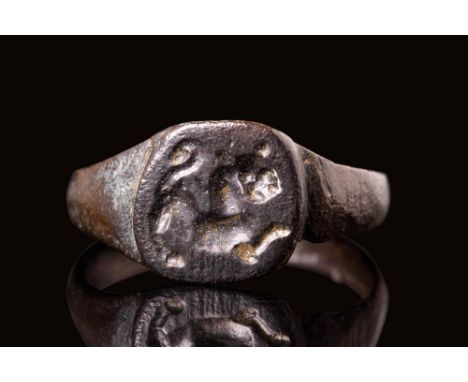 Ca. AD 900 - 1300 A Medieval bronze ring with a D-shaped hoop and stepped shoulders featuring a circular bezel. The bezel fea