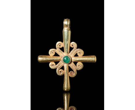 Ca. AD 500 - 700 A Byzantine 21.5 ct gold cross pendant with a deep green emerald cabochon secured by a gold frame. The cross