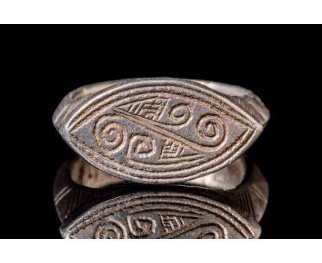 Ca. AD 800 - 1300 A Medieval silver ring with an almond-shaped bezel. It is engraved with geometrical, spiral, and labyrinthi