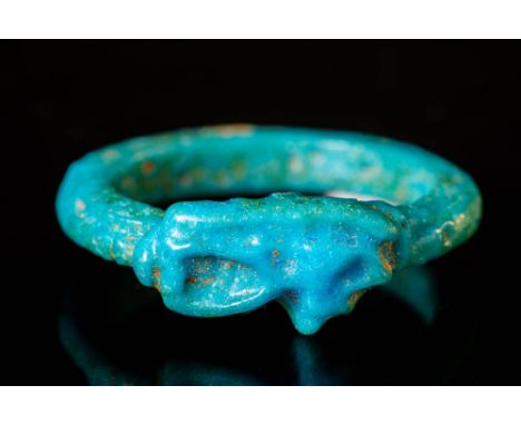 Ca. 1550 - 1070 BC An Egyptian faience ring with its centre adorned with a meticulously crafted eye of Horus motif. The lustr