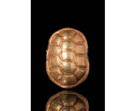 Ca. 1550 - 1069 BC A hand-carved hardstone, gilded turtle shell bead with naturalistic features. The uninscribed underside de