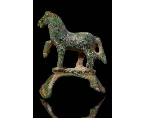 Ca. 300 - 100 BC A bronze ritual model of a horse depicted with its right front leg propped up. The horse is shown resting on