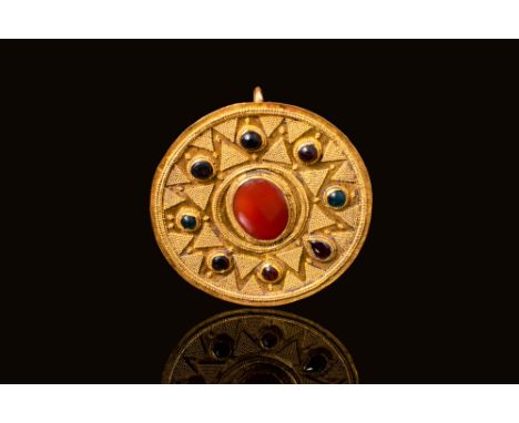 Ca. 100 BC - AD 100 A Hellenistic gold circular brooch made of a thin sheet of gold, decorated with a central bezel made of r
