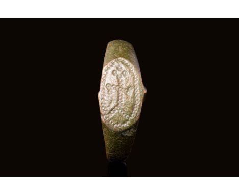 Ca. AD 600 A Byzantine bronze ring with a D-shaped hoop. It has wider shoulders, connected to an elongated bezel depicting a 