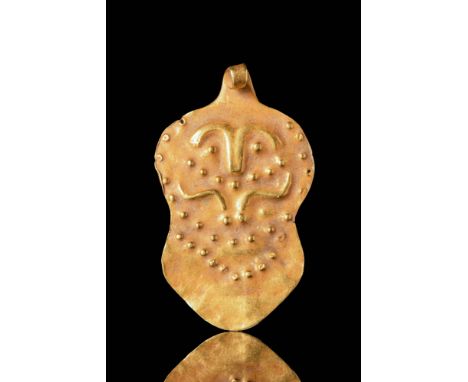 Ca. 700 - 300 BC A gold pendant in the form of a gold leaf, depicting a human face composed of a nose, eyebrows and eyes. The