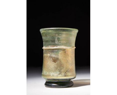 Ca. AD 200 - 400 A Roman glass vessel of translucent green glass with rainbow iridescence which presents a very striking silh