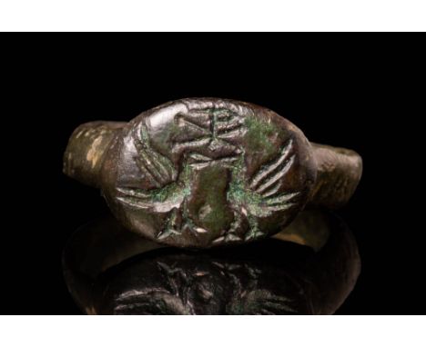 Ca. AD 900 - 1200 A Medieval bronze ring with a round hoop and a D-shaped section connected to an elongated bezel. The bezel 