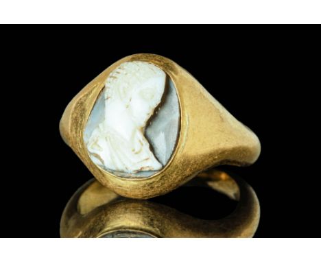 Ca. AD 200 - 300 A Roman gold finger ring composed of a round hoop, enlarged on the shoulders to form a large bezel. The beze