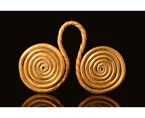 Ca. 750 - 650 BC An Etruscan gold spectacle pendant composed of two coils of wire, which become thick at the centre and linke