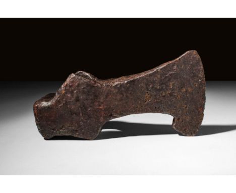 Ca. AD 800 - 1000 A hand-forged iron axe head with a broad blade flaring to a curved cutting edge. It has a socket with an ov